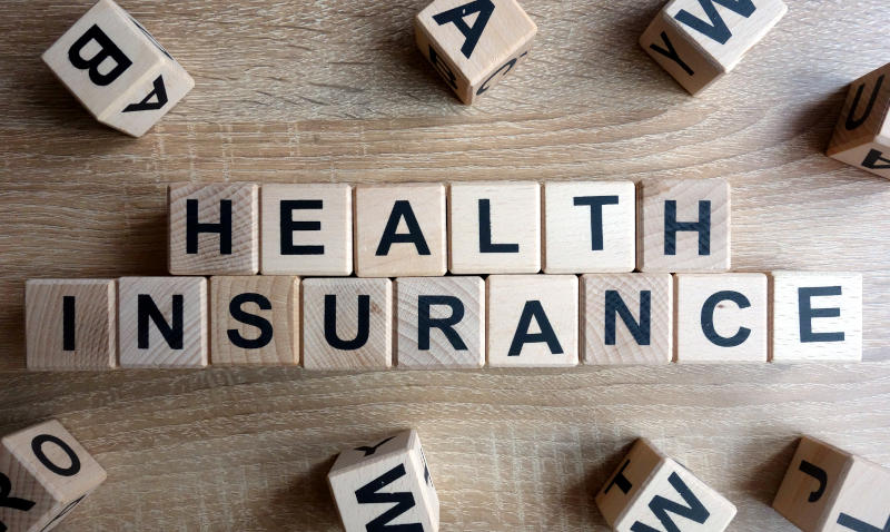 Scrabble bricks on a table that say the words health insurance