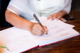 A bride signing in the book at her wedding