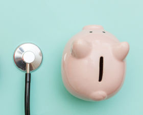 A stethoscope, a heart and a piggy bank